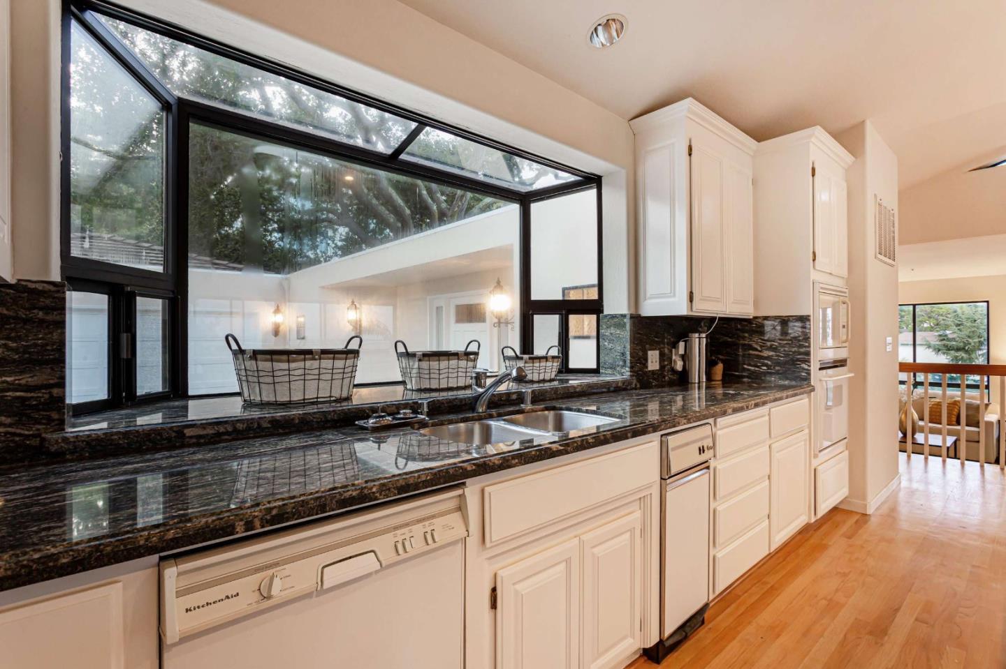745 Holly Road Belmont, CA 94002 - Photo 17 of 50 a kitchen with stainless steel appliances a sink window and cabinets