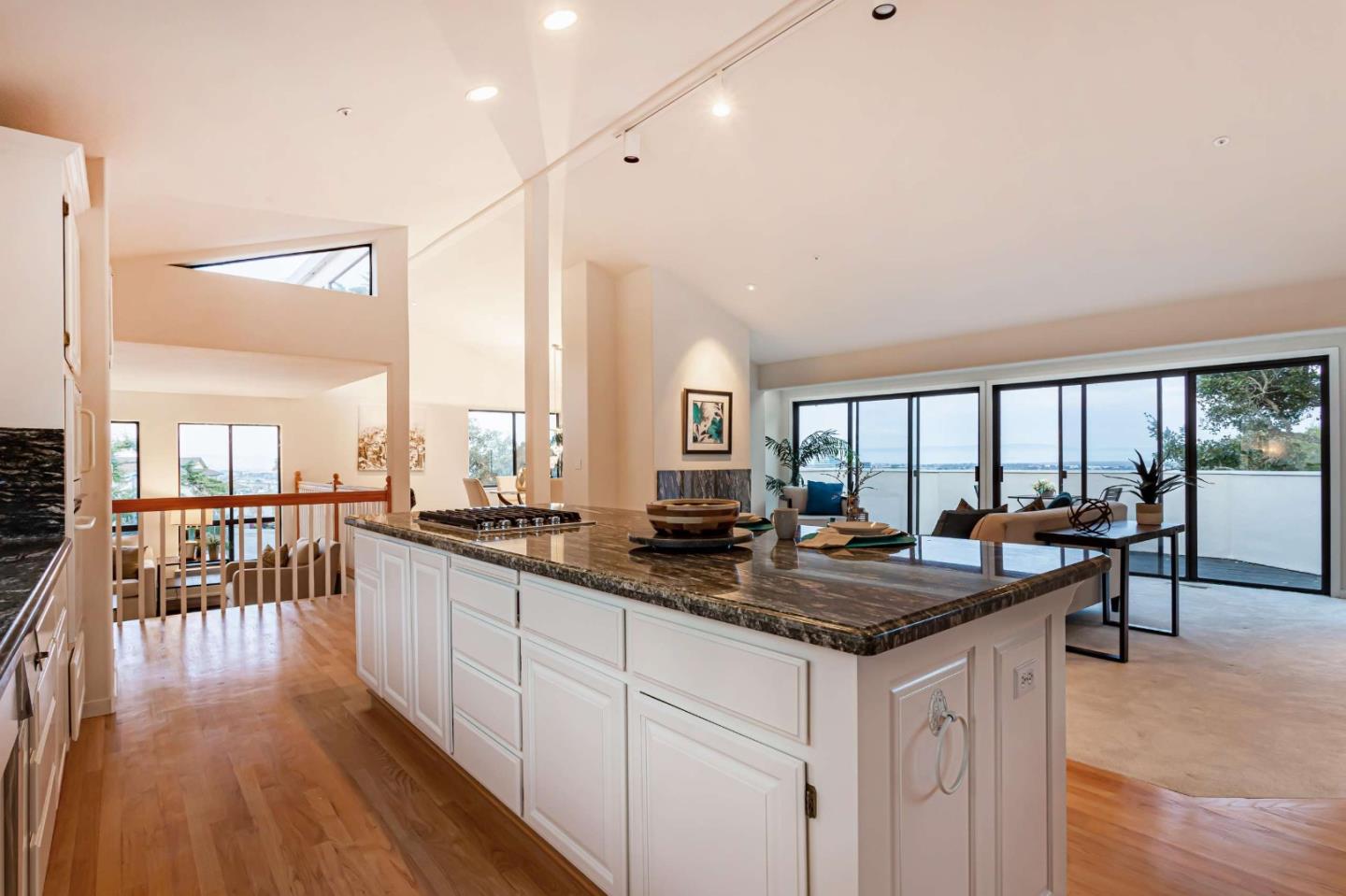 745 Holly Road Belmont, CA 94002 - Photo 18 of 50 a kitchen with granite countertop a stove a sink a dining table and chairs with wooden floor