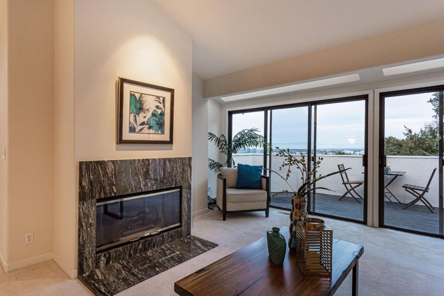 745 Holly Road Belmont, CA 94002 - Photo 9 of 50 a living room with furniture a floor to ceiling window and a fireplace