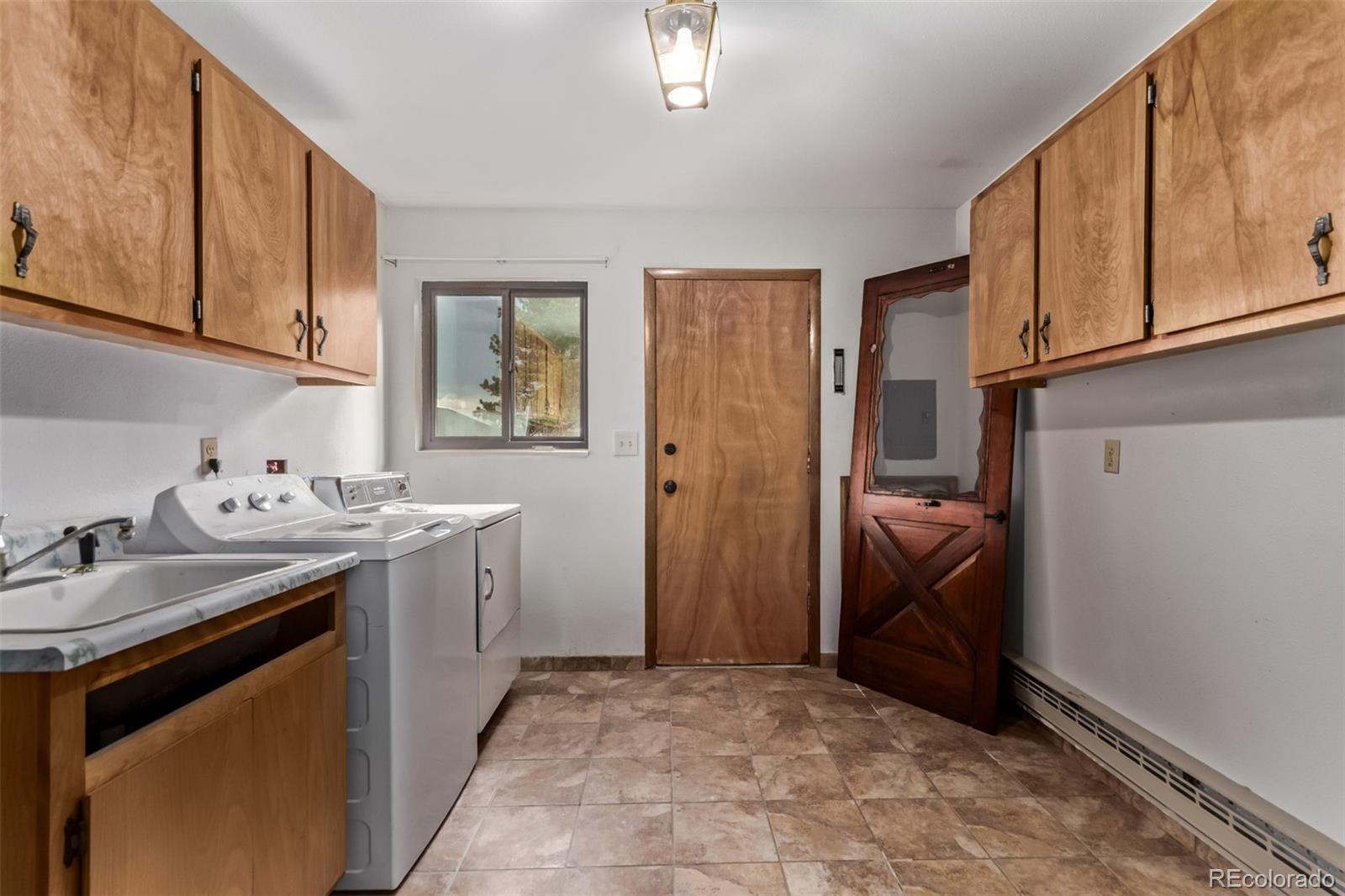 15481 Rist Canyon Road Bellvue, CO 80512 - Photo 32 of 50 a utility room with cabinets washer and dryer