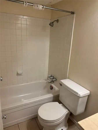 a white toilet and tub next to a bathroom
