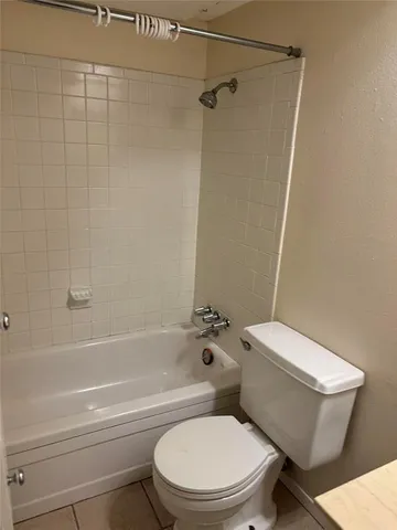 a white toilet and tub next to a bathroom