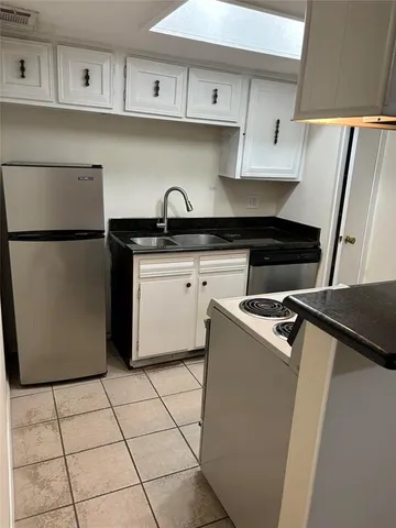 a kitchen with a sink a refrigerator and cabinets