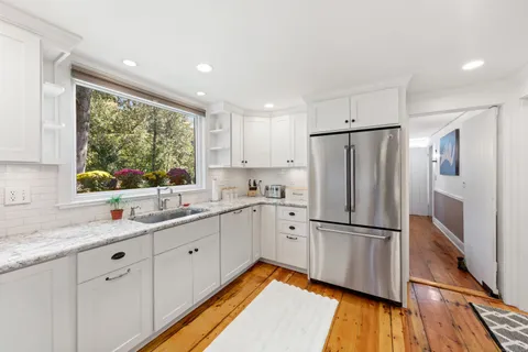 a kitchen with white cabinets and white appliances