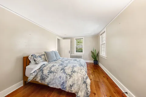 a bed sitting in a spacious bedroom next to a window
