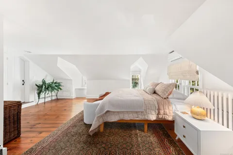 a bedroom with furniture and a wooden floor