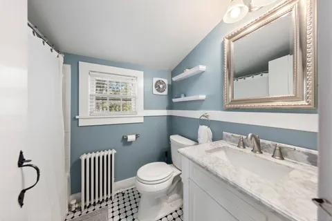 a bathroom with a granite countertop toilet sink and mirror