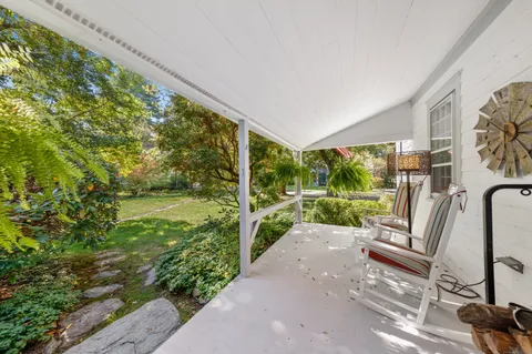 a view of a porch with furniture and garden
