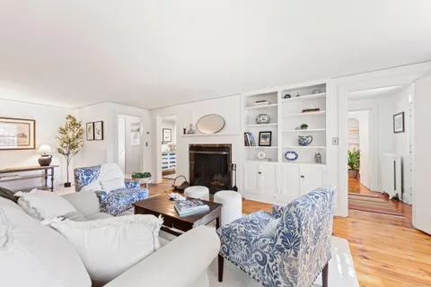 a living room with furniture a fireplace and wooden floor