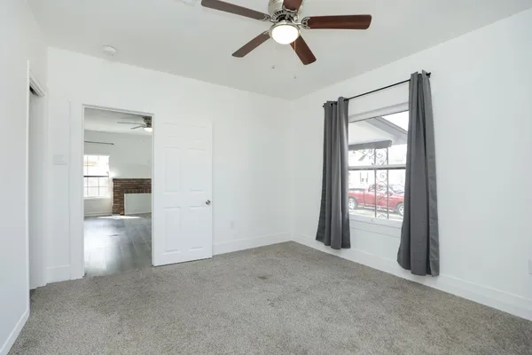 a view of a room with a ceiling fan and windows