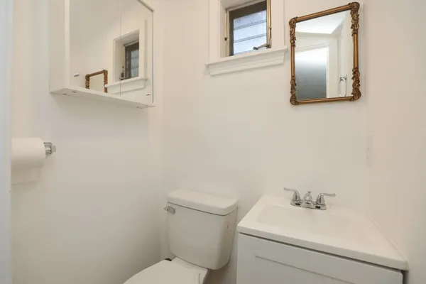 a bathroom with a toilet sink and mirror