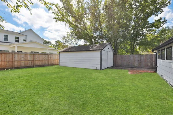 a view of a backyard with a garden and tree