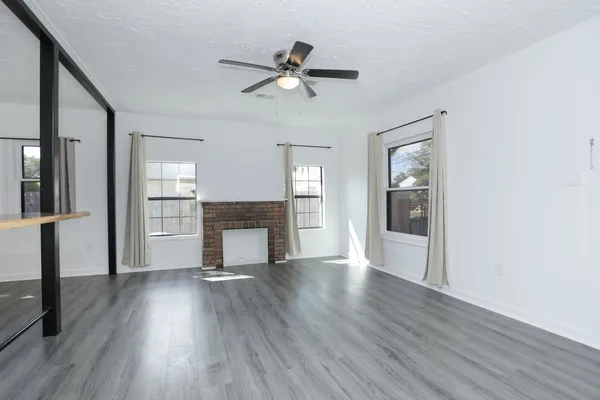 a view of empty room with wooden floor and fireplace