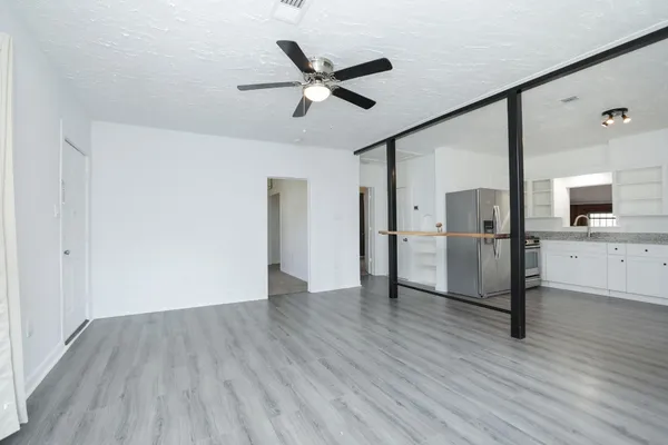 a view of a livingroom with a kitchen counter tops and wooden floor