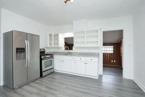 a kitchen with granite countertop white cabinets and stainless steel appliances