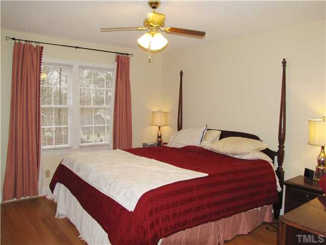 103 Dabney Road Cary, NC 27511 - Photo 12 of 25 a bedroom with a bed chandelier and a window