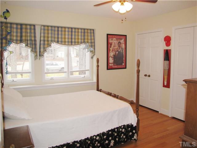 103 Dabney Road Cary, NC 27511 - Photo 14 of 25 a spacious bedroom with a bed and a chandelier