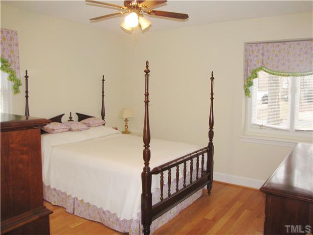 103 Dabney Road Cary, NC 27511 - Photo 16 of 25 a bedroom with a bed and a chandelier