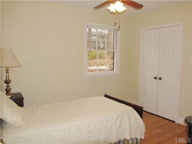 103 Dabney Road Cary, NC 27511 - Photo 18 of 25 a bedroom with a bed and a chandelier