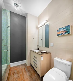 a bathroom with a sink a toilet and shower