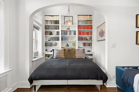 a bedroom with a bed a table and a painting on the wall