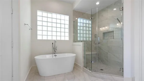 a white bath tub sitting next to a shower