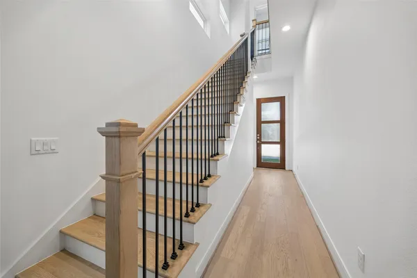 a view of staircase with railing and white walls
