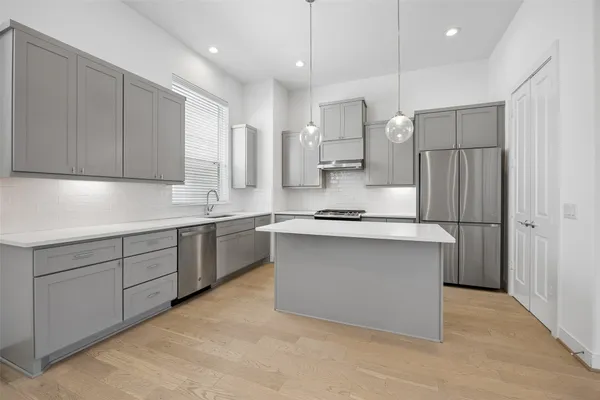 a kitchen with stainless steel appliances granite countertop a sink stove and cabinets