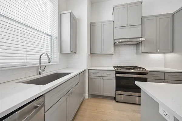 a kitchen with stainless steel appliances a sink stove and cabinets