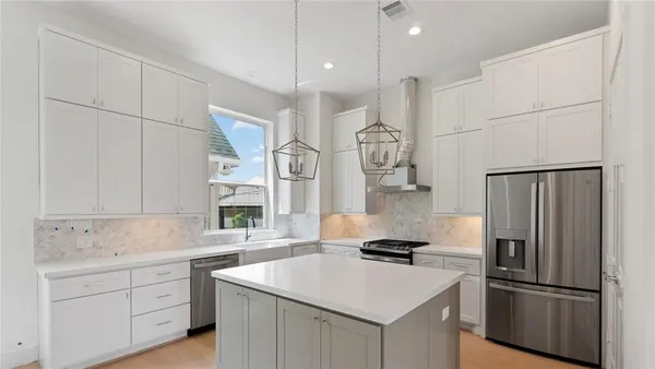 a kitchen with white cabinets and stainless steel appliances