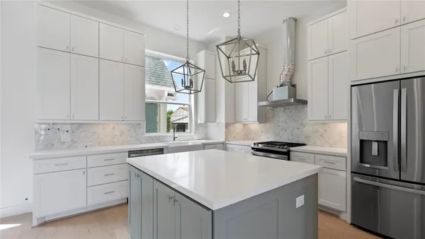 a kitchen with a sink stainless steel appliances a refrigerator and cabinets