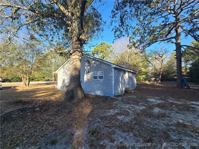 a view of a house with large trees