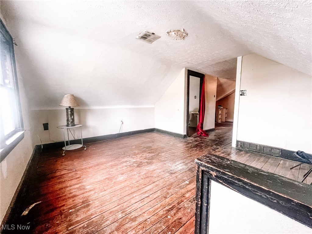 1547 Hillcrest Road Cleveland, OH 44118 - Photo 17 of 23 Third Floor featuring wood-type flooring, a textured ceiling, and lofted ceiling