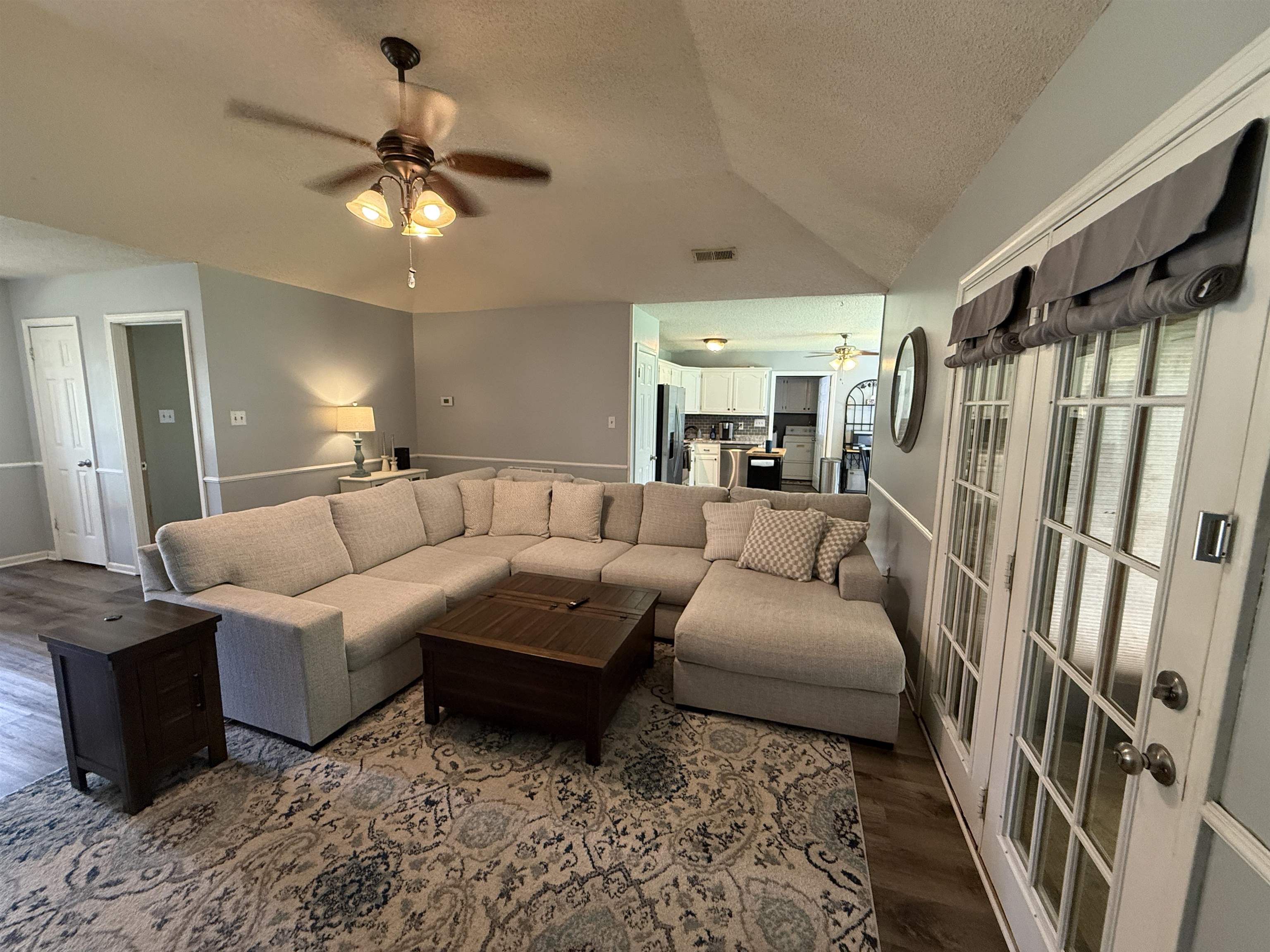 185 Mignon Road Atoka, TN 38004 - Photo 11 of 34 Living area featuring wood-finish flooring, two-panel interior doors, and a vaulted ceiling with a ceiling fan