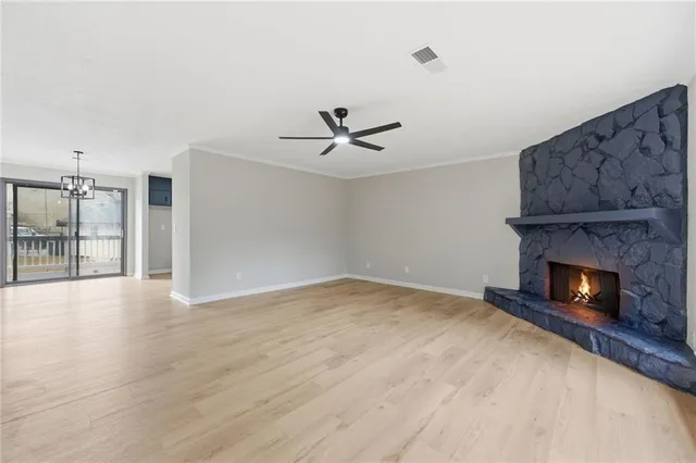 a view of an empty room with a fireplace and a window