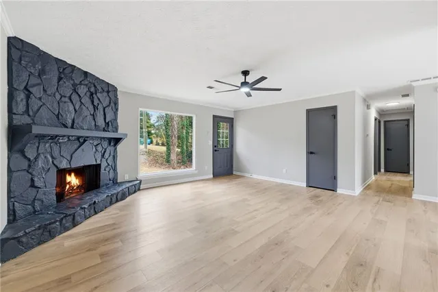 a view of an empty room with a fireplace and a window