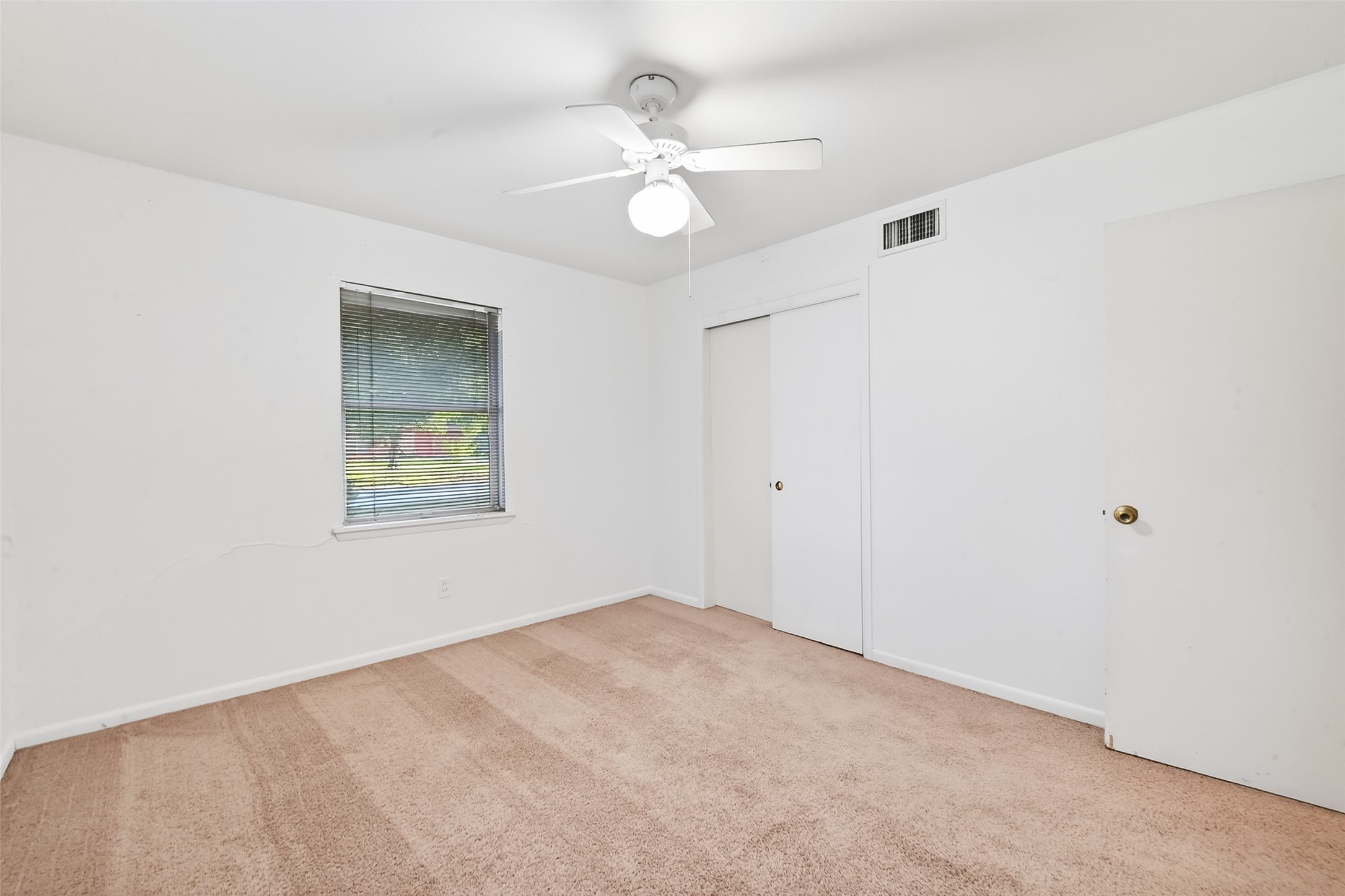 5422 Spellman Road Houston, TX 77096 - Photo 22 of 27 an empty room with a chandelier fan and windows