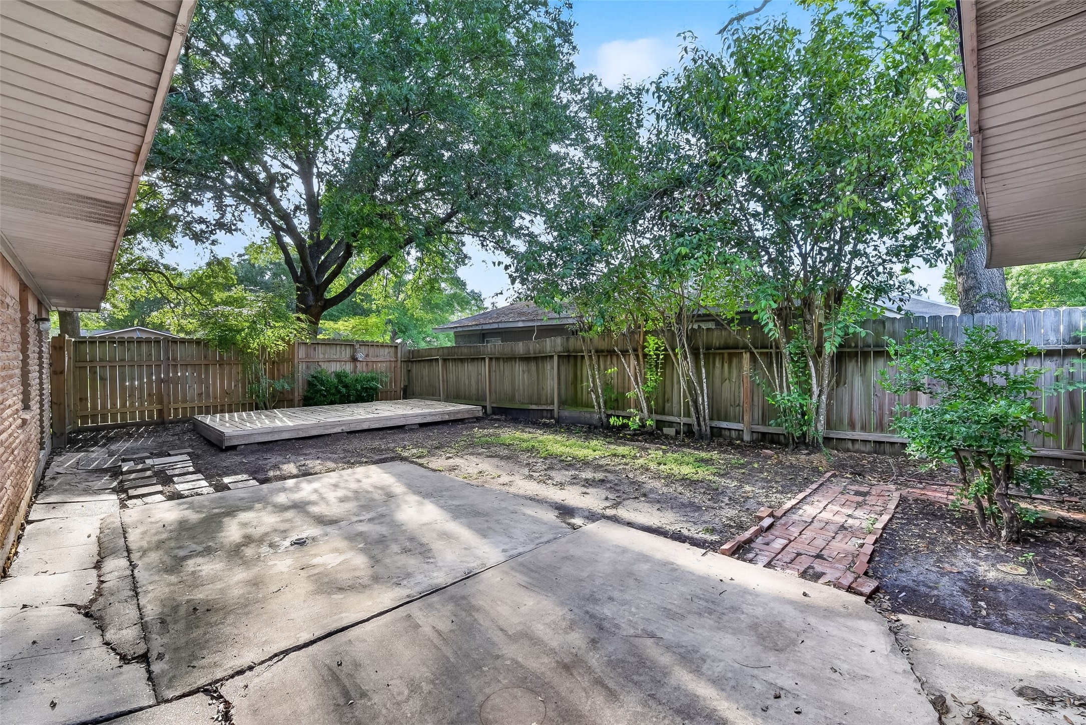 5422 Spellman Road Houston, TX 77096 - Photo 24 of 27 a view of a backyard with large trees and wooden fence