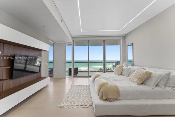 a spacious bedroom with a large bed and large windows