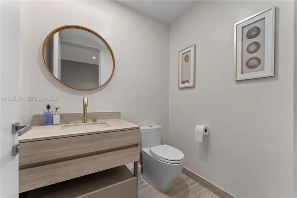 a bedroom with a bed television on desk and a window