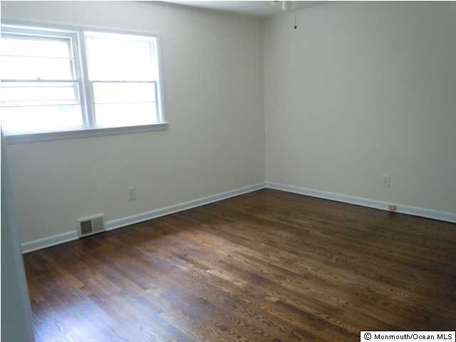 25 Kenmore Road Freehold, NJ 07728 - Photo 6 of 12 an empty room with wooden floor and windows