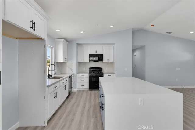 a large kitchen with cabinets stainless steel appliances and a counter space