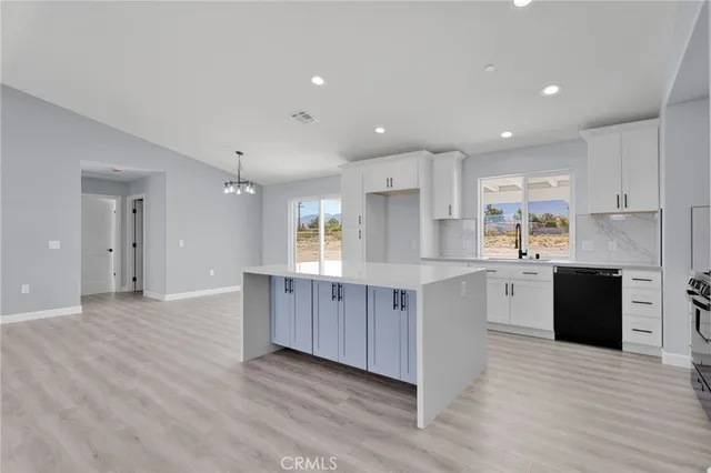 a large kitchen with wooden floors and stainless steel appliances