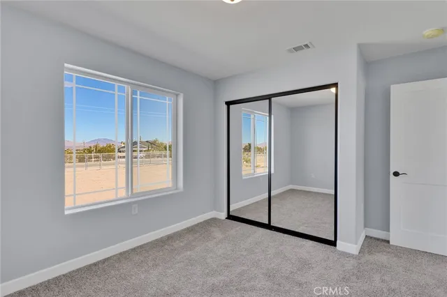 an empty room with windows and closet