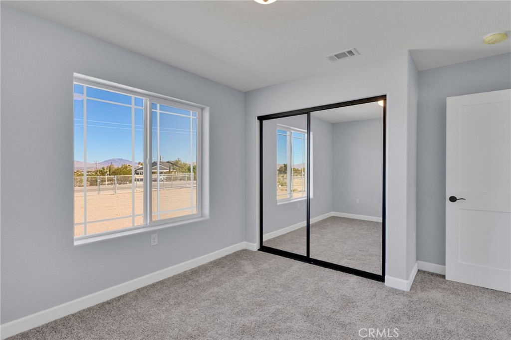 36165 Sutter Road Lucerne Valley, CA 92356 - Photo 24 of 42 an empty room with windows and closet
