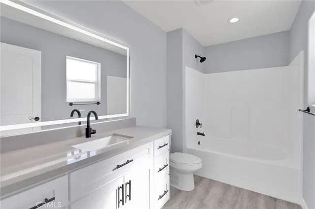 a bathroom with a granite countertop sink a toilet and a bathtub