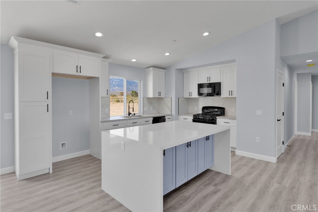 36165 Sutter Road Lucerne Valley, CA 92356 - Photo 3 of 42 a large kitchen with stainless steel appliances kitchen island a large counter top and a wooden floors