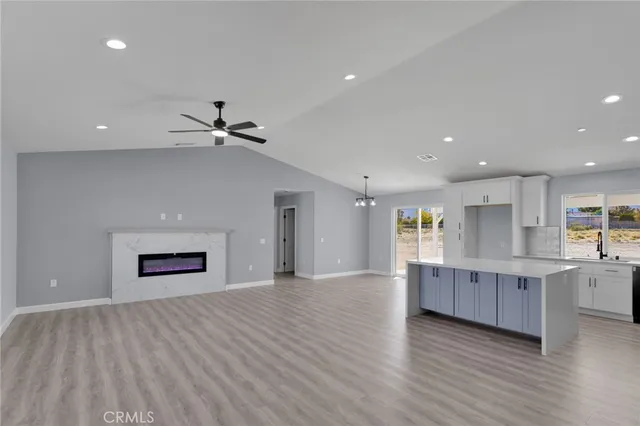 a view of a kitchen with wooden floor and a ceiling fan