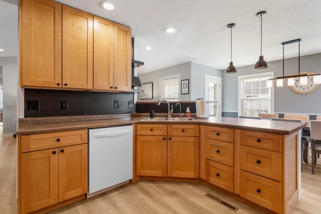 a kitchen with cabinets appliances and a wooden floor