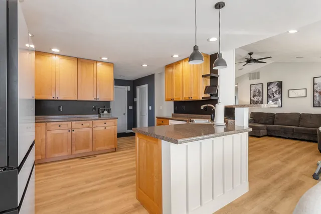 a kitchen with stainless steel appliances granite countertop a sink a stove and a wooden floors
